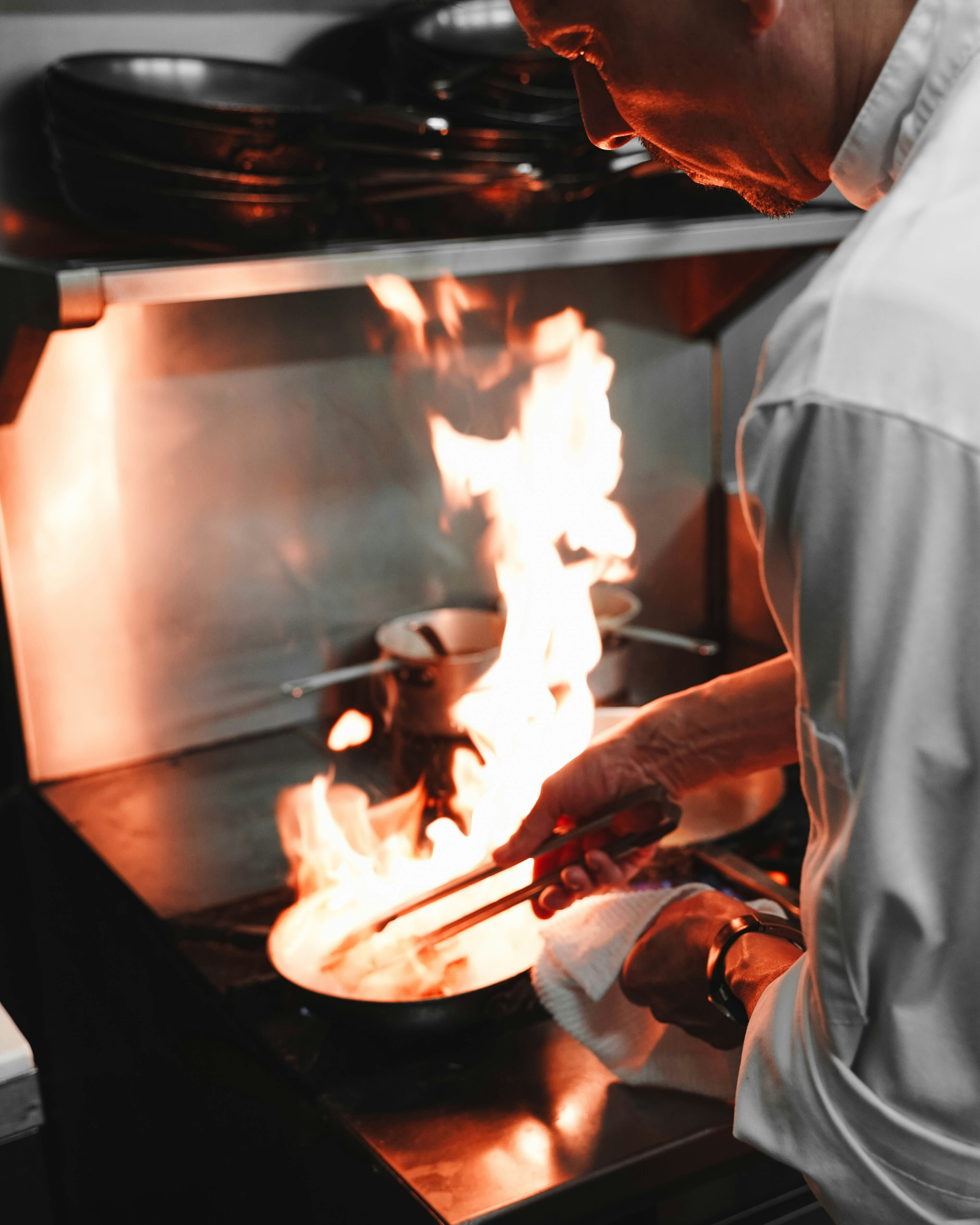 Chef preparing food over an open flame